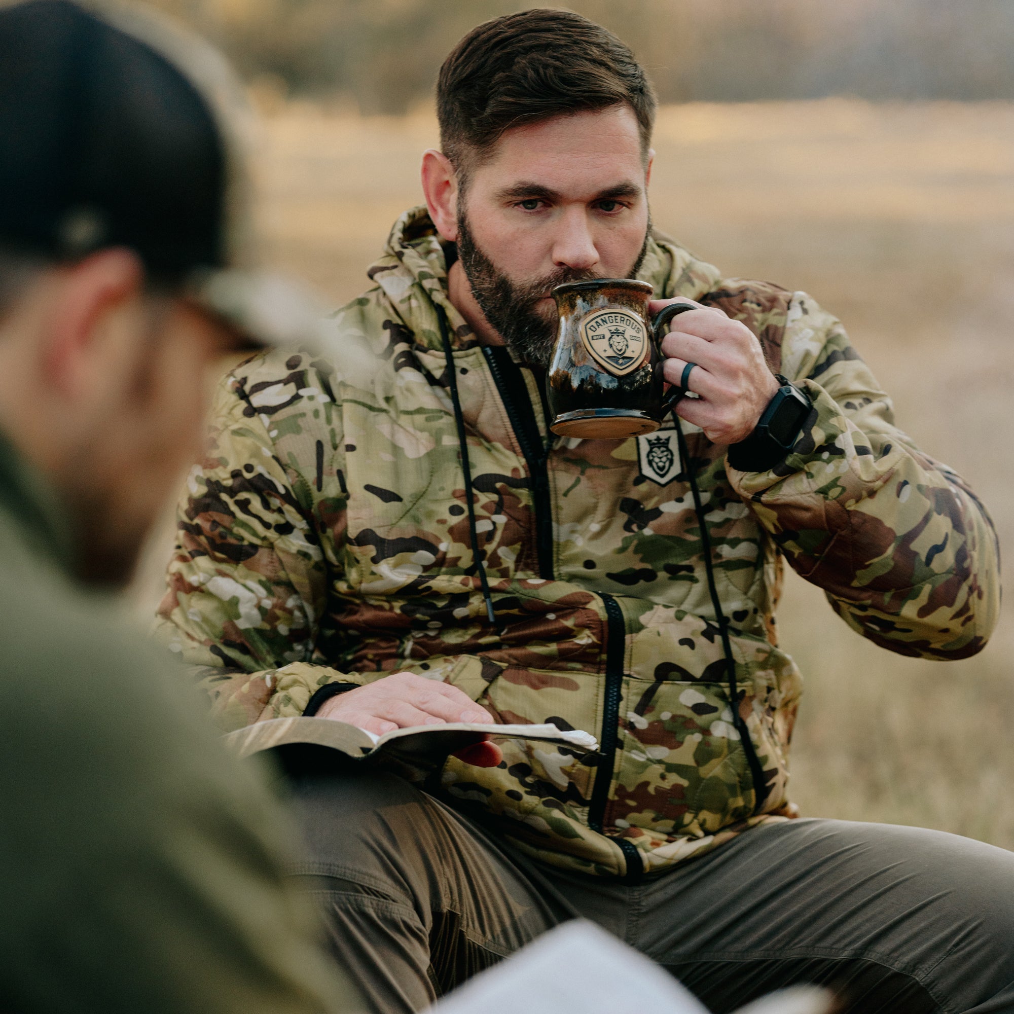 camo jacket drinking coffee